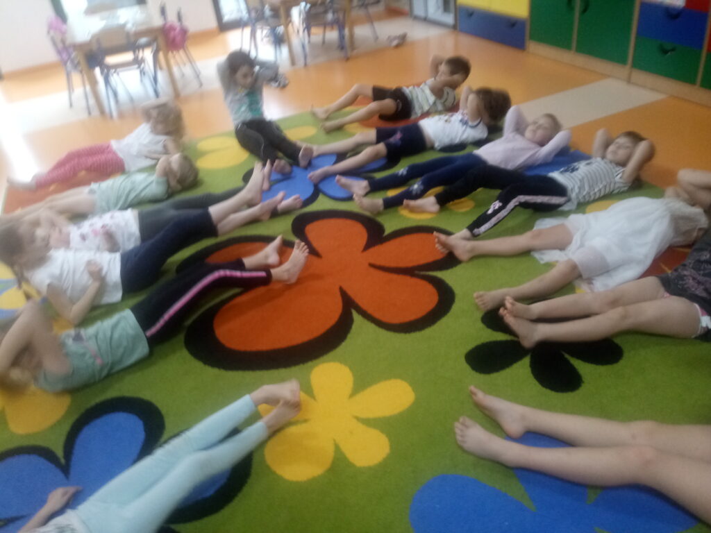dzieci ćwiczą na leżąco